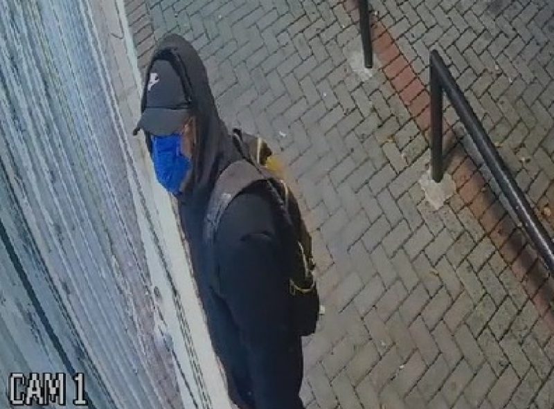Ladrão encapuzado e de máscara prestes a arrombar a loja