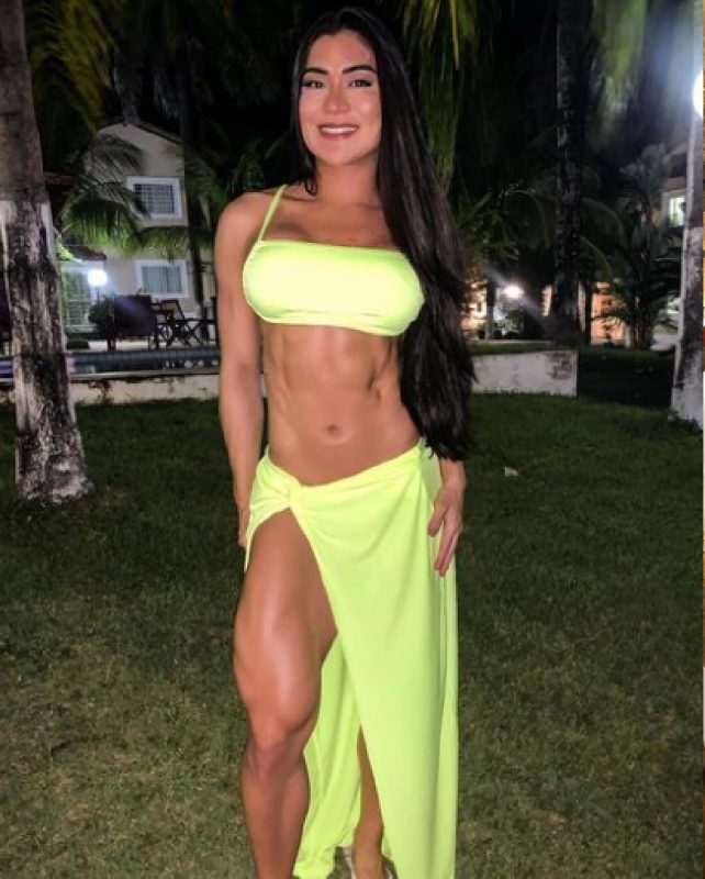 Influenciadora fitness de vestido mostrando boa forma 