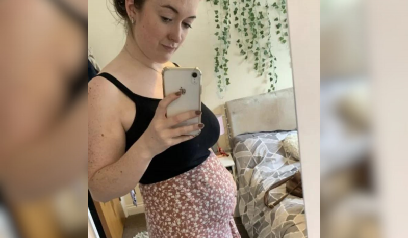 Mulher tirando foto no espelho mostrando barriga inchada, como de grávida, por conta de endometriose