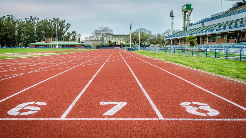 Pista de atletismo onde árbitros acompanham as provas