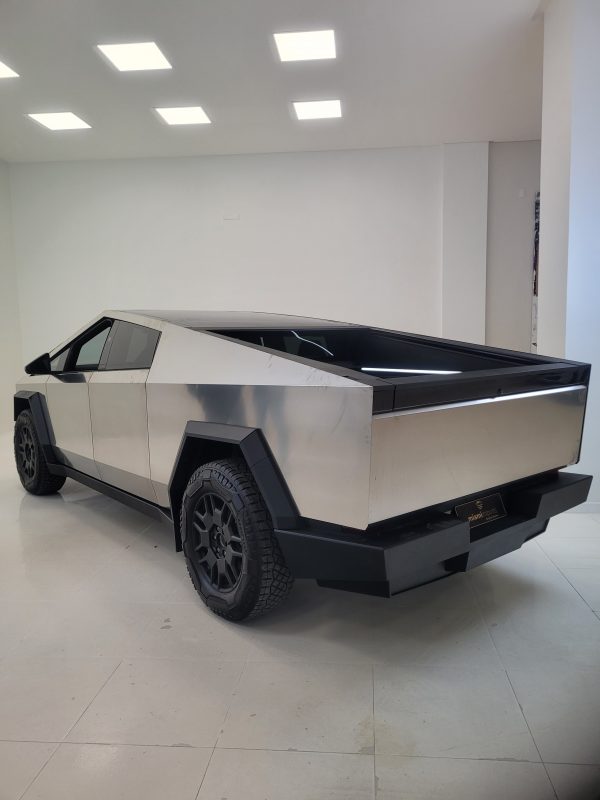 Imagem de um Tesla Cyber Truck prateado na garagem