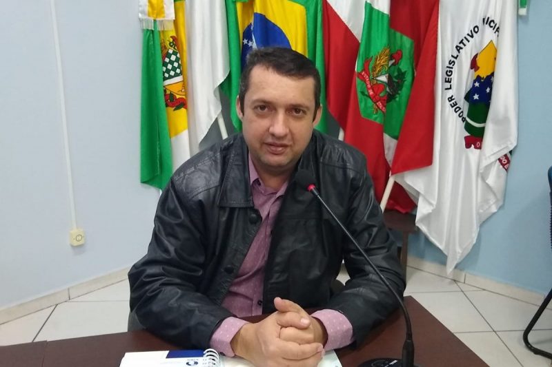 vereador Everson Jandrei Weber sentado em uma mesa da câmara de vereadores de saudades