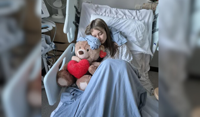 Foto mostra menina em cama de hospital agarrada a urso de pelúcia
