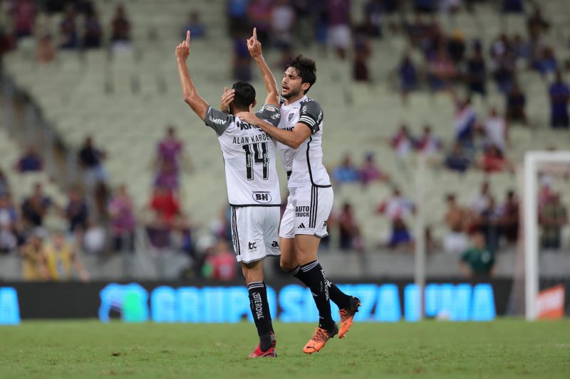 Alan Kardec levanta as mãos enquanto é abraçado por atleta do Atlético-MG