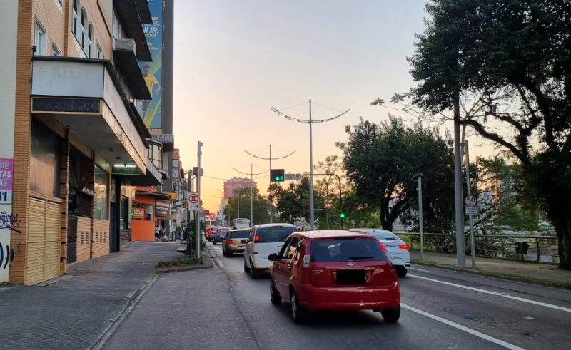 Avenida onde está o estacionamento em que o assaltante cometeu o crime, com carros em movimento 