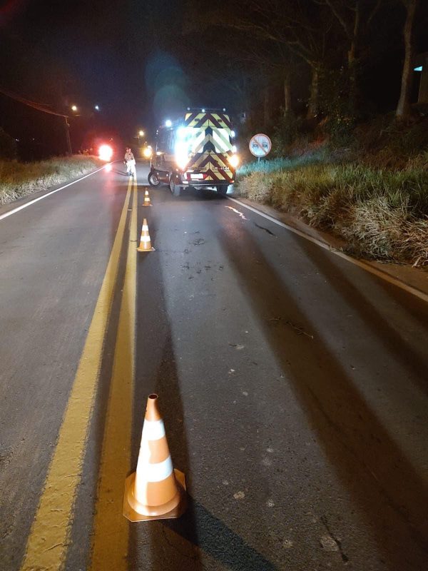 Viatura dos bombeiros e cones sinalizando estrada onde homem foi encontrado morto