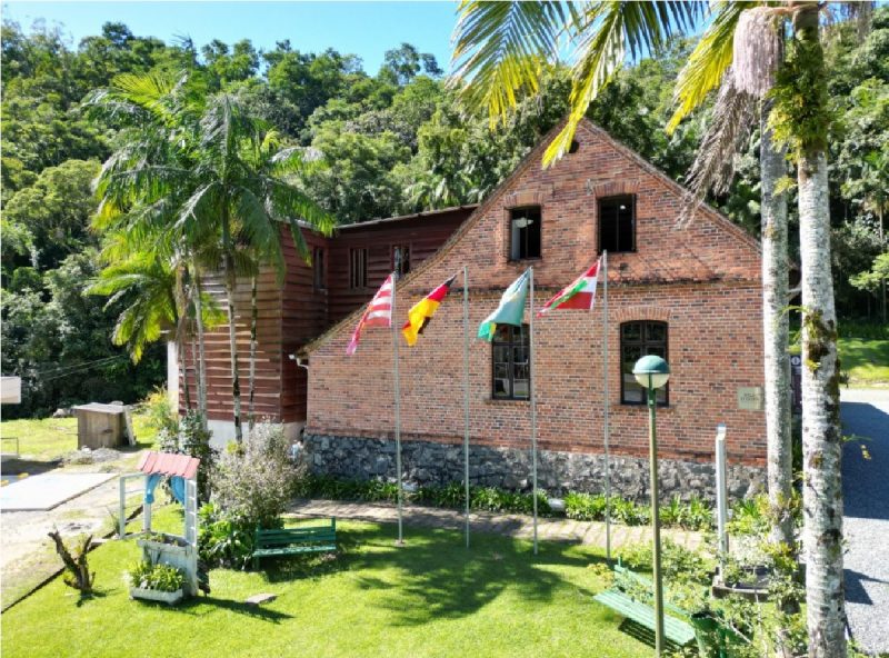 Passeio guiado começa a partir Centro Cultural da Vila Itoupava: fachada do centro com as bandeiras hasteadas