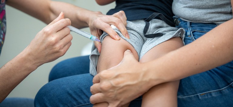 Criança toma vacina para coqueluche