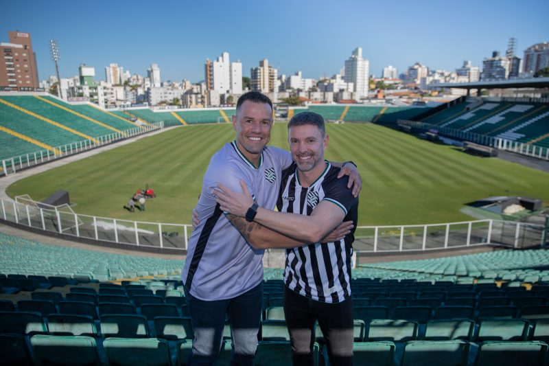 Wilson e Fernandes, com a camisa do Figueirense, se abraçam na arquibancada do estádio Orlando Scarpelli