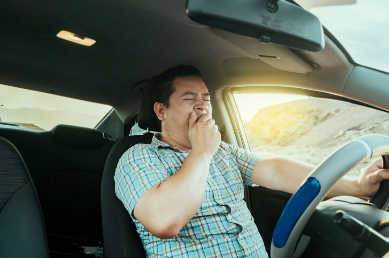 homem com sono dirigindo um carro