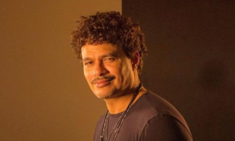 Na imagem aparece o cantor Léo Maia com um leve sorriso e posando para foto