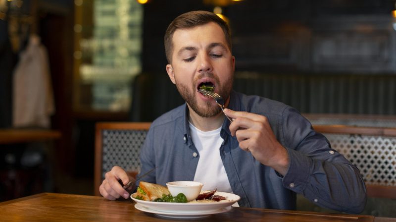 Homem comendo prato de comida