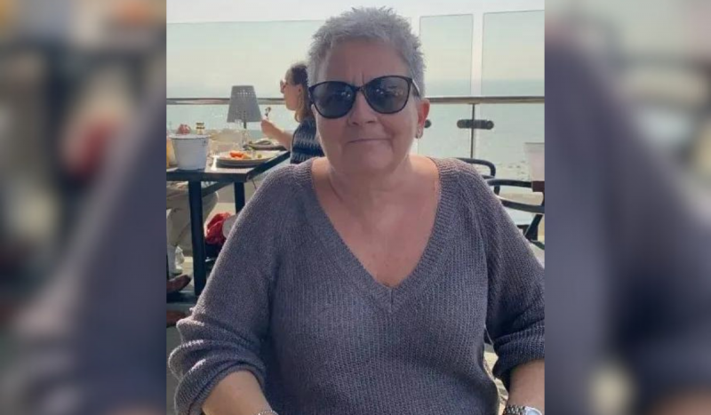 Paciente com câncer terminal - Foto mostra mulher branca de cabelos grisalhos e curtos sentada em cadeira usando blusa de tricô cinza e óculos escuros