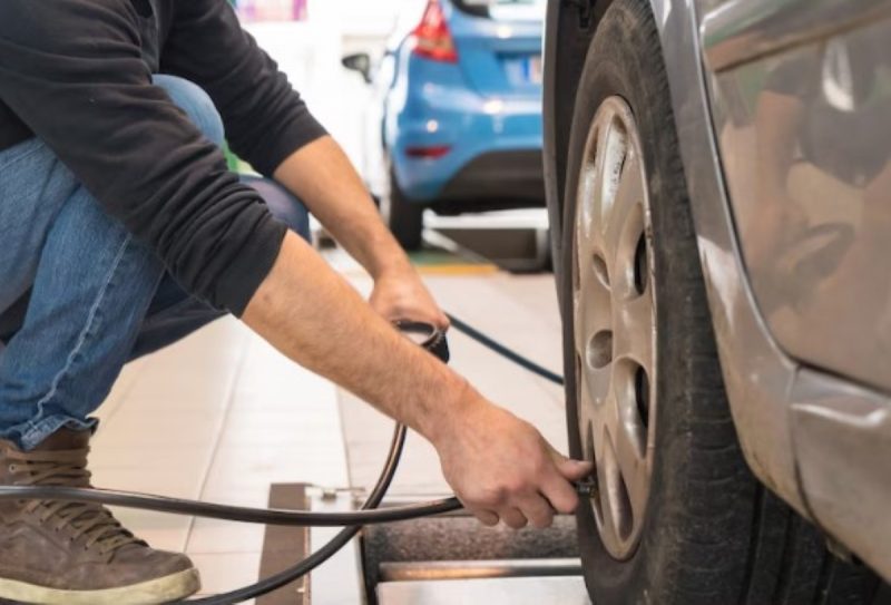 na foto aparece a calibragem ideal para o seu carro e um pneu sendo calibrado