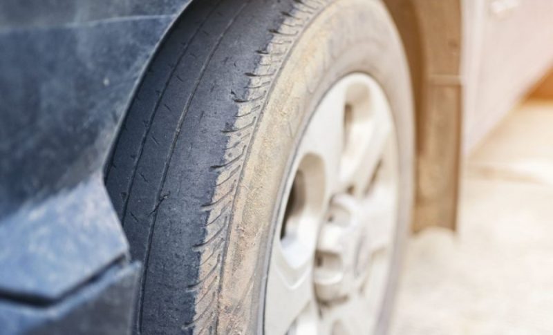 na imagem aparece um dos pneus do carro que está careca e precisa de manutenção