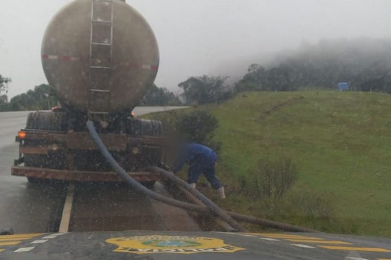motorista despejando soro de leite às margens de rodovia