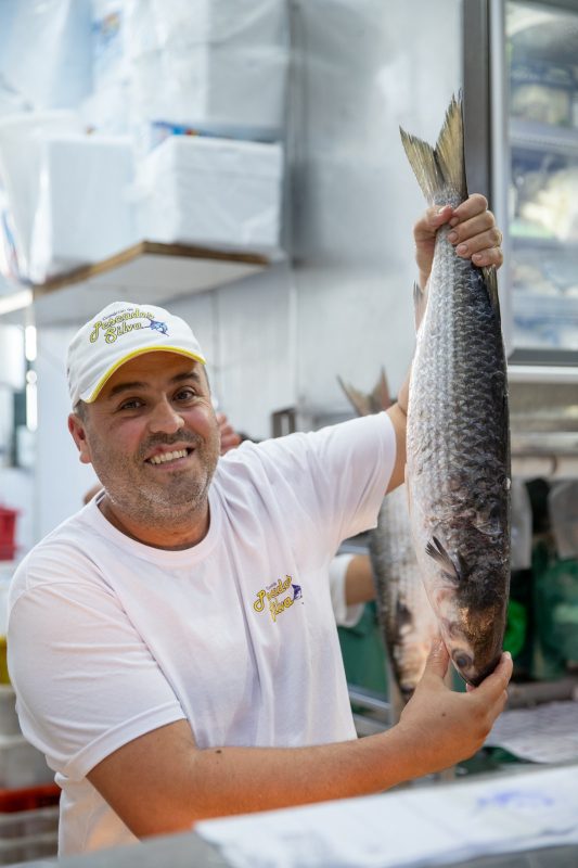 Germano Rigoto segura uma das tainhas que vende na sua peixaria 