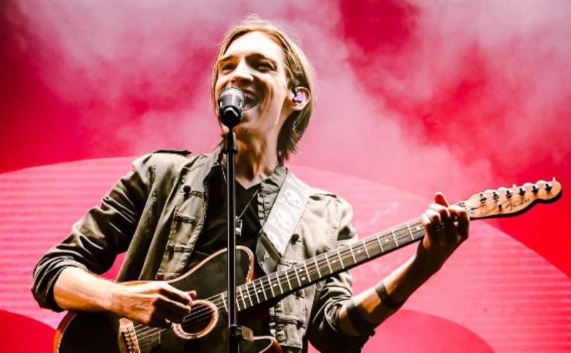 Na imagem aparece o vocalista da banda The Calling Alex Band cantando e tocando guitarra