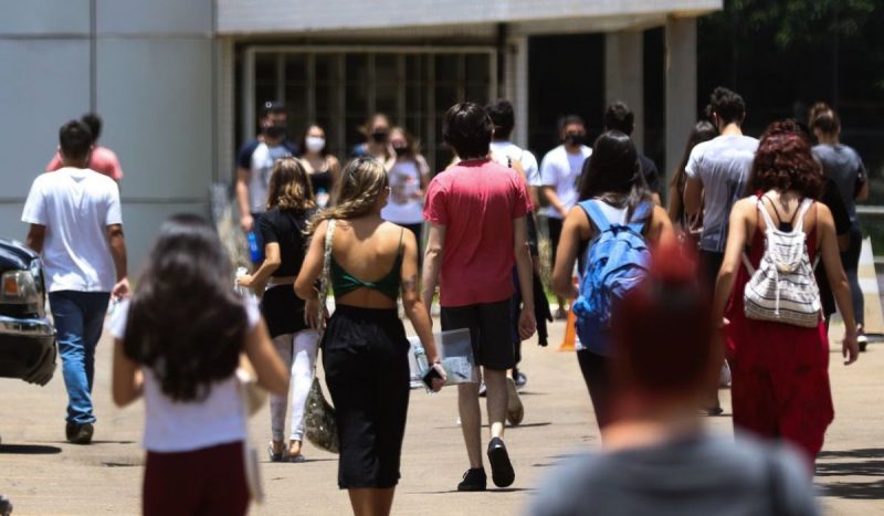 foto mostra pessoas de costas indo para a universidade para exemplificar fraude em bolsas do UniEdu