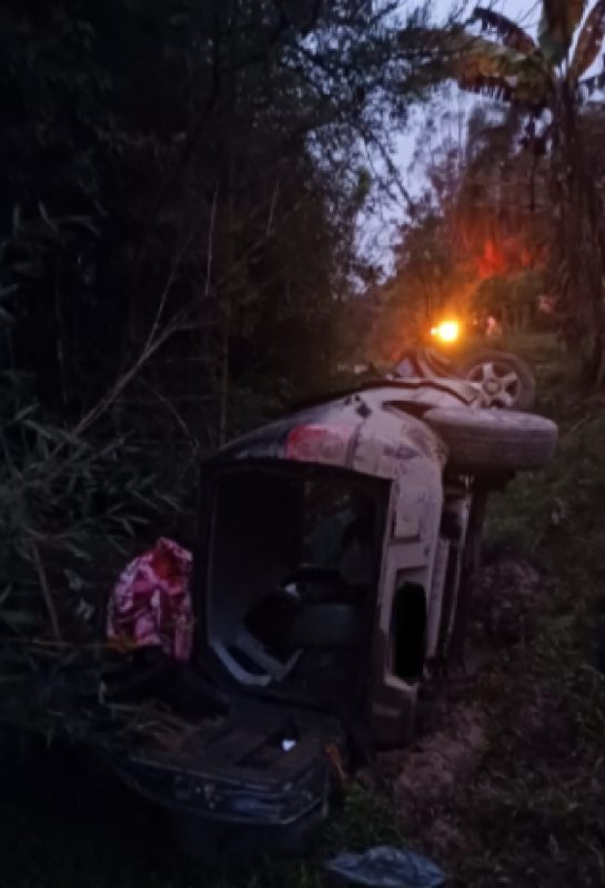 Carro capotado de lado com parte de trás arrancada 