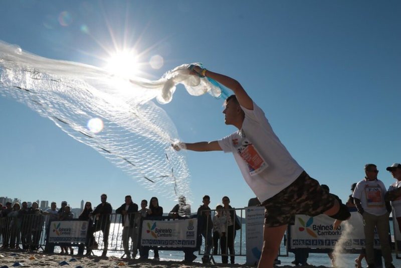 Foto mostra pescador jogando rede em campeonato 