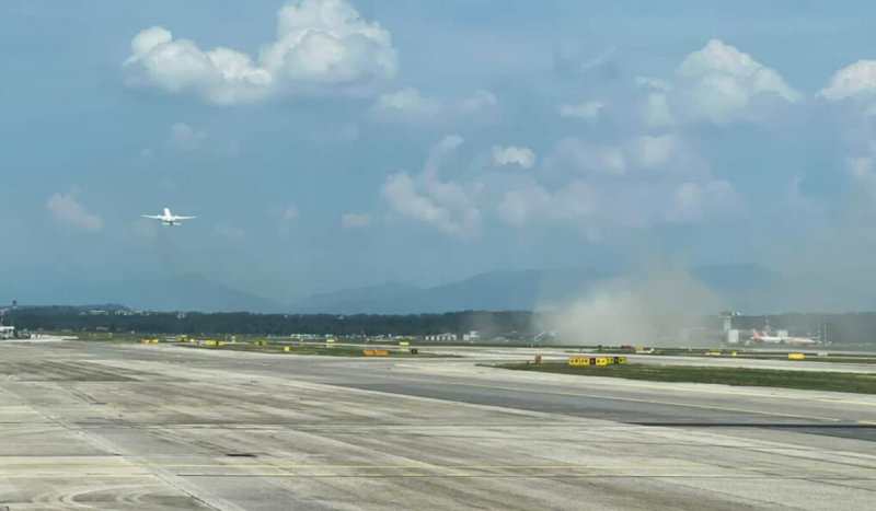 Avião da Latam ao longe encoberto por poeira levantada após pouso frustrado