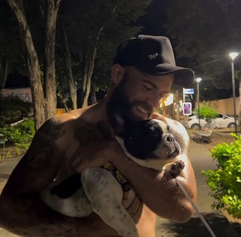 Alisson segurando o Bulldog no colo durante o reencontro emocionante 