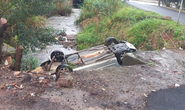 Carro capotado dentro de córrego foi visto por moradores que passavam pelo local