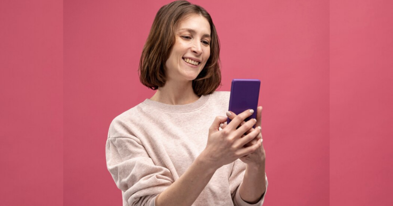 Mulher segurando o celular sorrindo