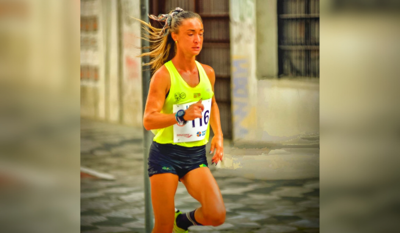 Atleta Luisa Giampaoli, do RS, falecida de leptospirose - mulher branca, bronzeada, correndo com short preto curto e regata amarela com inscrição no peito