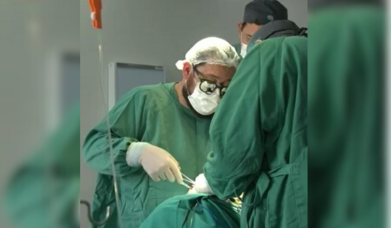 Cirurgião vestindo terno verde operando paciente