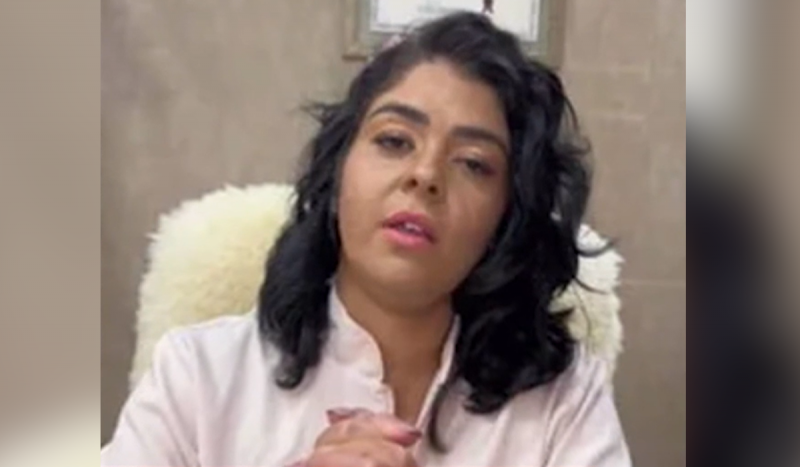 Lúcia Felippe Janot Marinho, a rainha dos carecas - mulher negra de cabelos curtos e pretos gesticulando enquanto fala em vídeo. Ela usa batom rosa e sombra marrom nos olhos