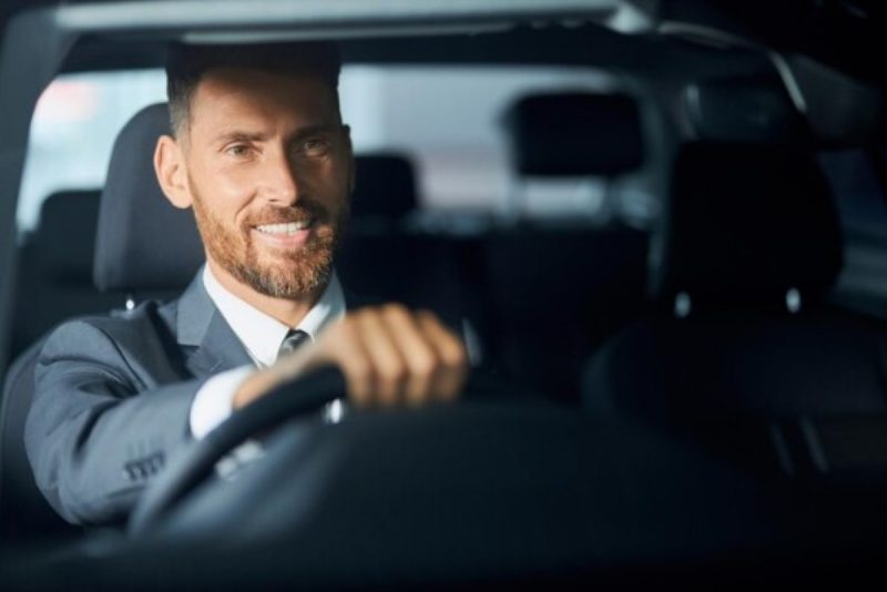 Motorista feliz por ter abastecido e economizar na gasolina durante viagem