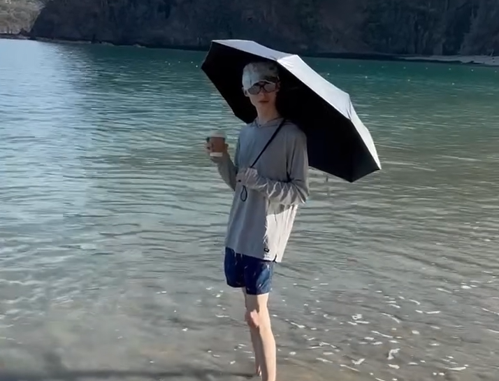 Brandon com um guarda-chuva na praia