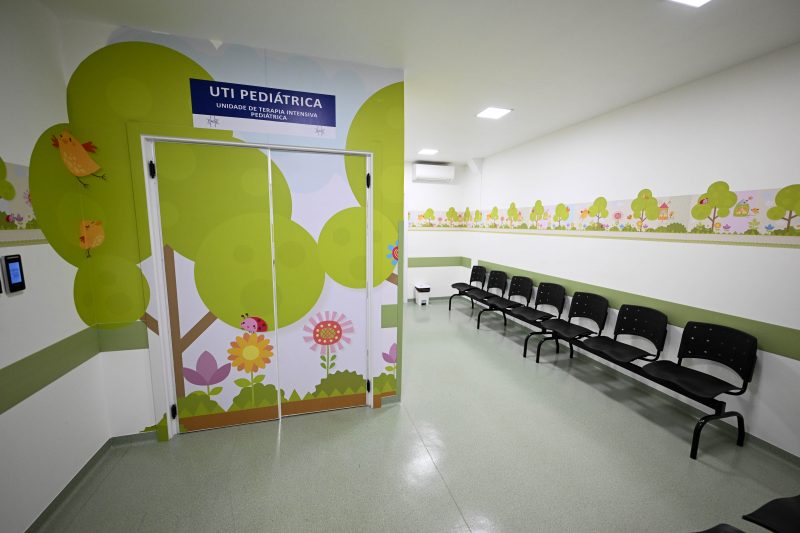 Hospital Oase de Timbó Imagem mostra ala da UTI pediátrica do hospital Oase de Timbó vazia. Na foto, há algumas cadeiras, uma parede pintada com imagens de árvores, flores e pássaros.