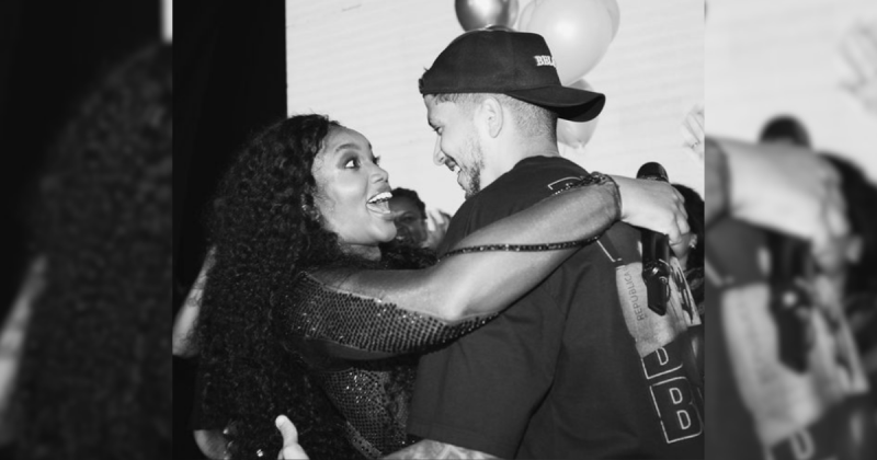 Yuri Lima abraçando a cantora Iza em foto preto e branco