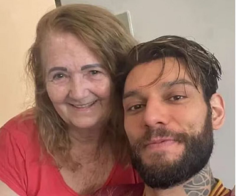 na foto aparece a avó de Lucas Lucco sorrindo e o artista em casa