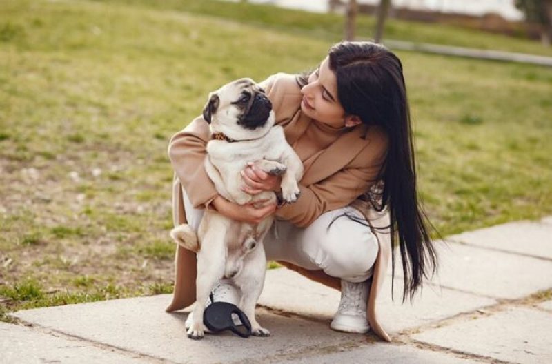 Mãe de pet e seu cachorro juntos na calçada 