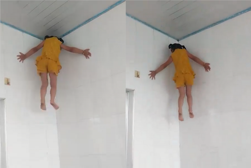 Criança escala parede com as mãos e pés na China