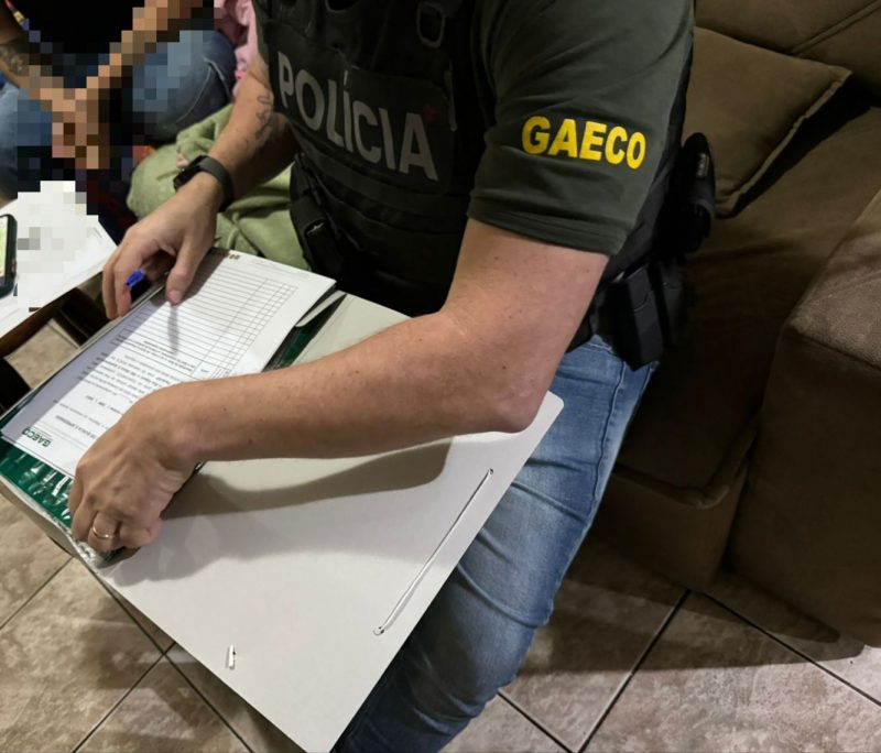 Policial do gaeco recolhendo provas 