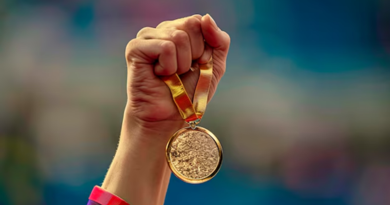 Imagem gerada por inteligência artificial de mão segurando medalha de ouro