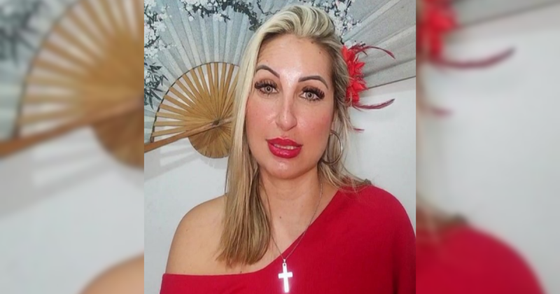 Mulher de vermelho, com cruz no peito e flor no cabelo