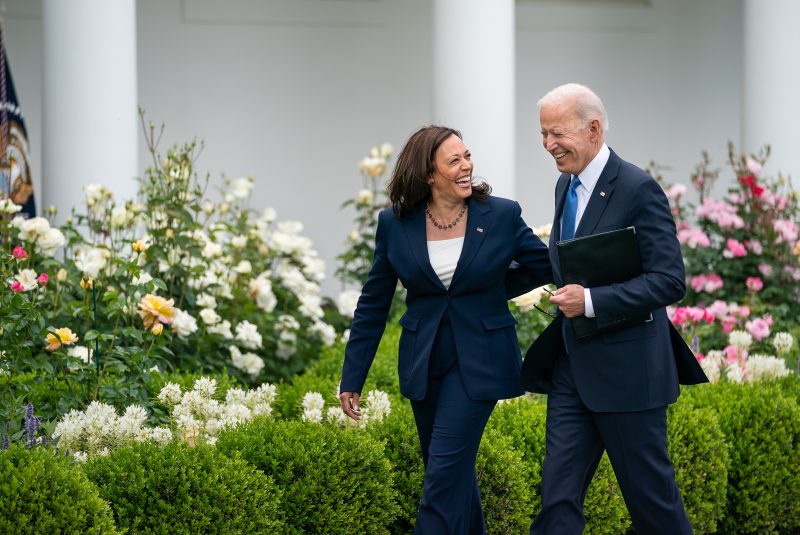 Imagem de Joe Biden andando com Kamala Harris sorridentes