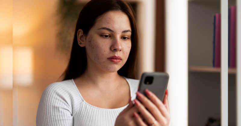 Mulher segurando celular com rosto sério