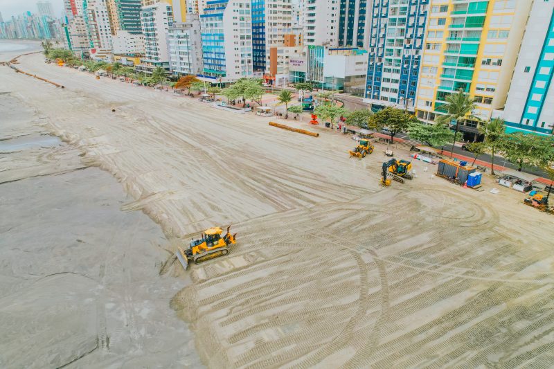 Imagem mostra obra de alargamento da faixa de areia, feita antes da reurbanização da orla de Balneário Camboriú