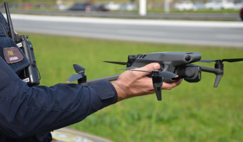 Policial segurando drones na mão