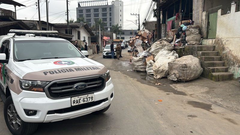 Viatura da polícia parada próxima a ferro velho