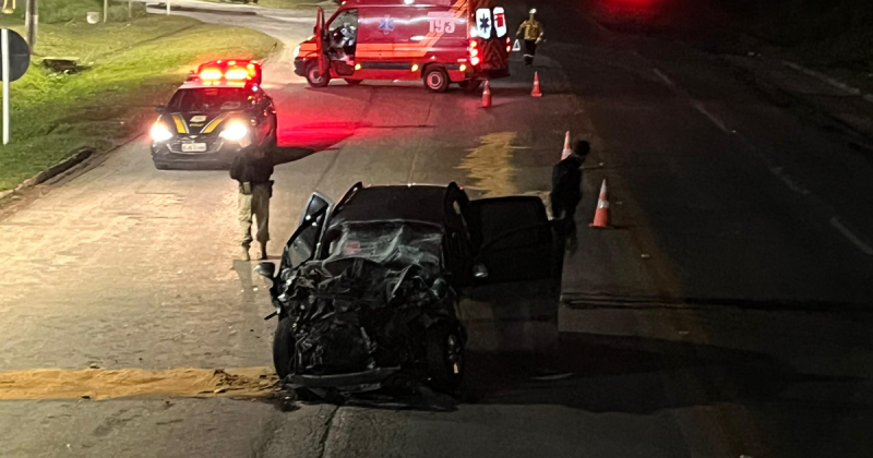 Imagem de carro com a frente destruída e homem preso no veículo