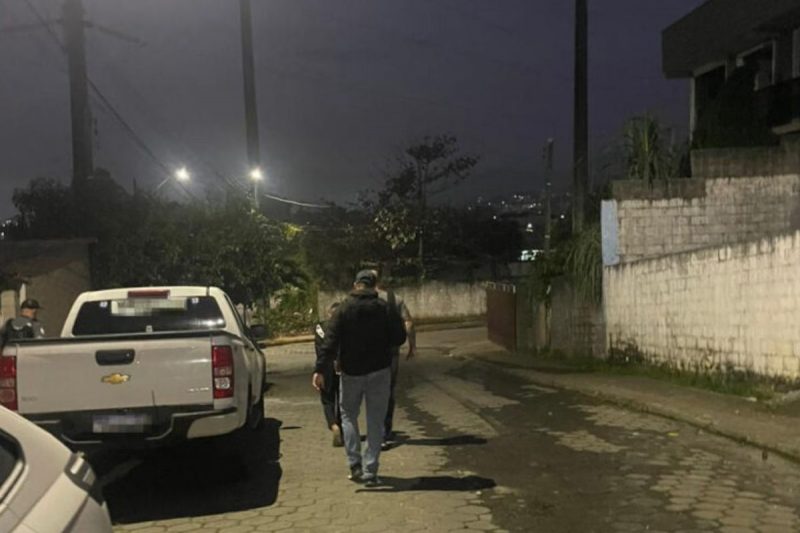 Suspeito de homicídio sendo conduzido pela polícia