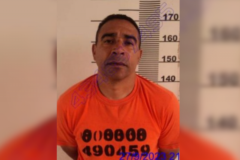 Manoel Delfino usando uniforme laranja da penitenciária